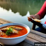 헝가리 할라스레 소개 - Photorealistic Hungarian halászlé fish soup served in a rustic riverside restaurant in Budapest, viv...
